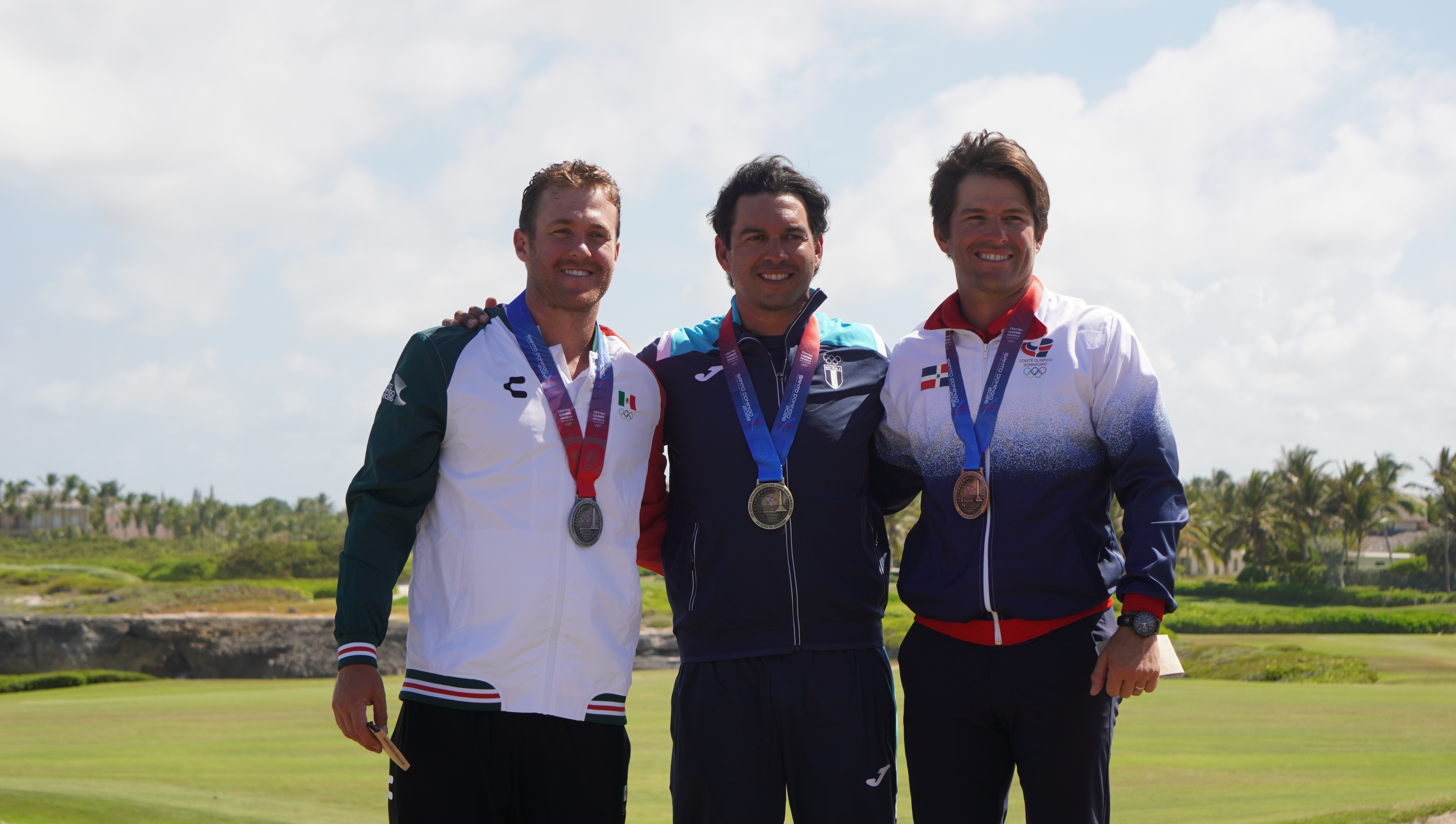 Tres golfistas medallistas posan juntos en un campo de golf