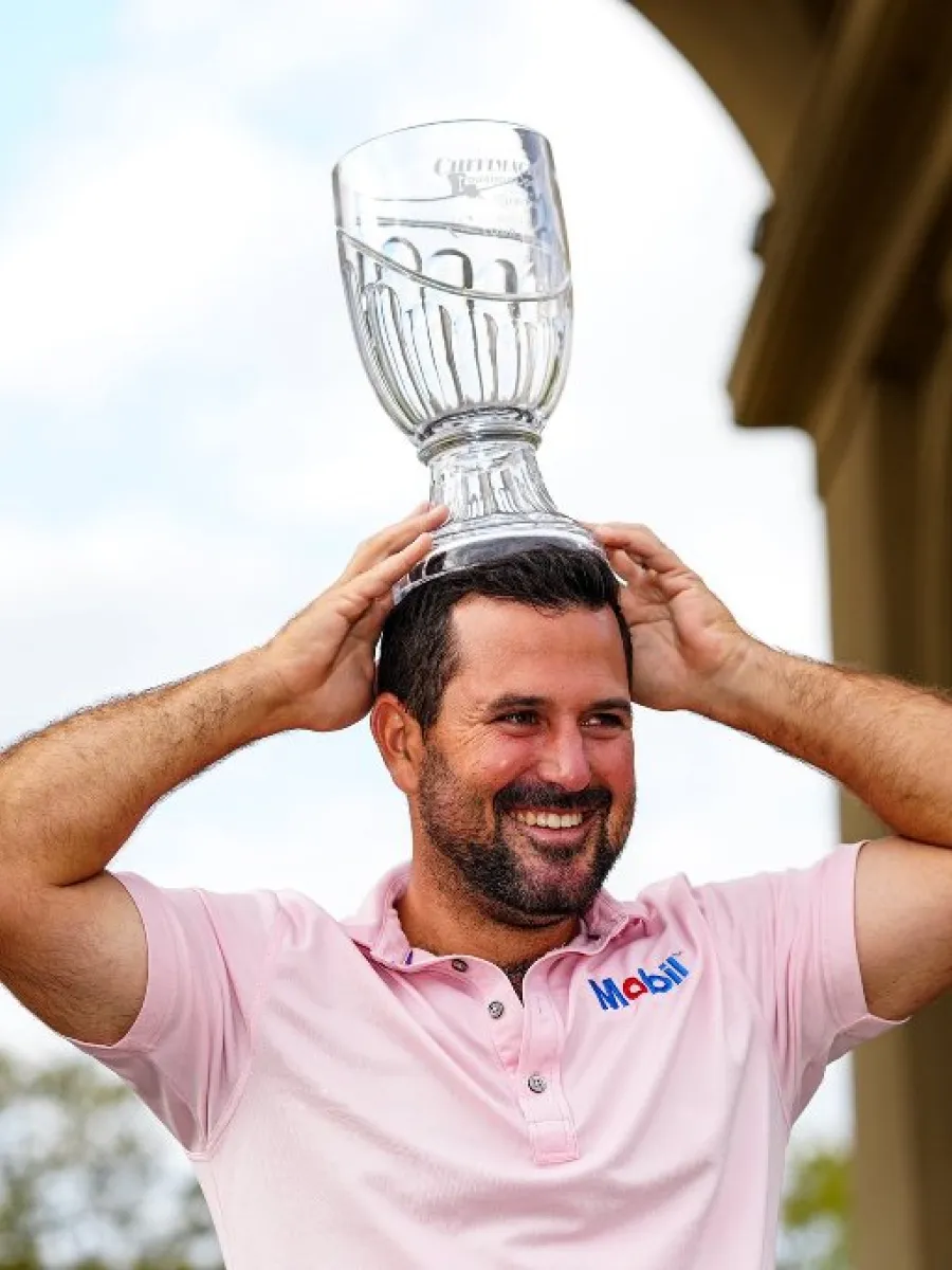Roberto Díaz celebra con un trofeo de golf